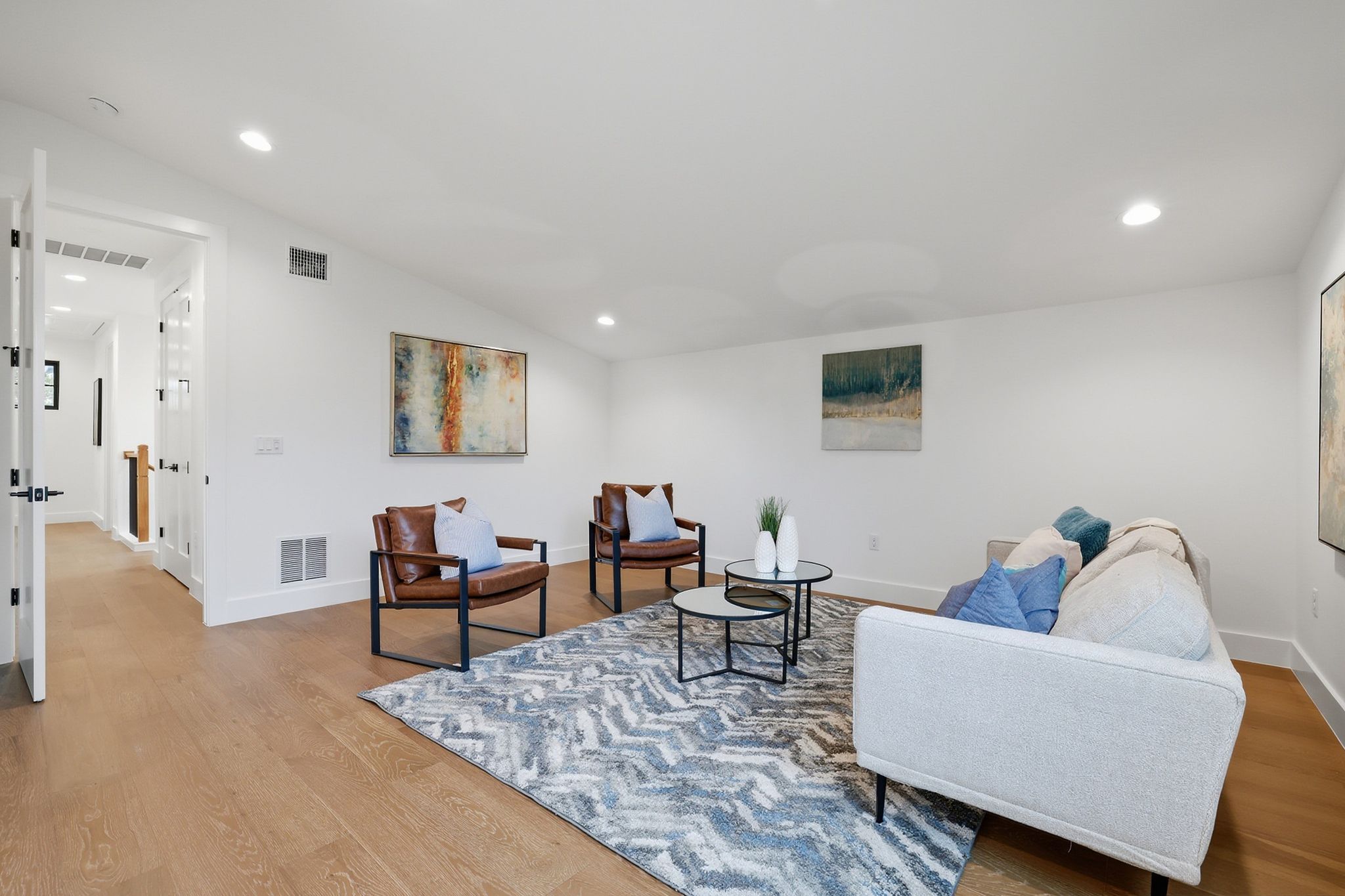 6611 Lexington Road Austin, TX 78757 - Photo 29 of 37 Bright living area featuring wood-finish flooring, recessed lighting, white walls, and a vaulted ceiling