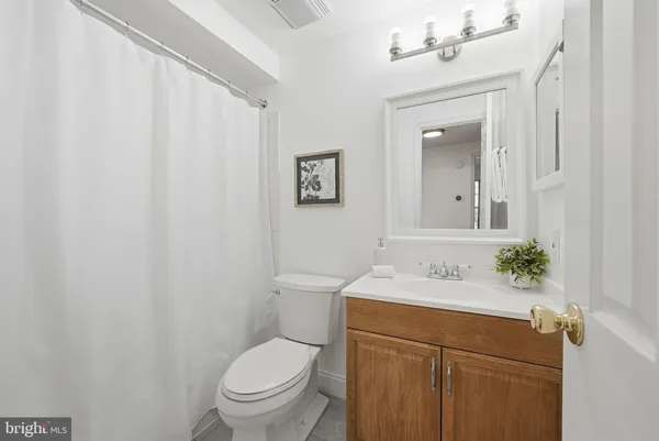 a bathroom with a sink vanity mirror and toilet