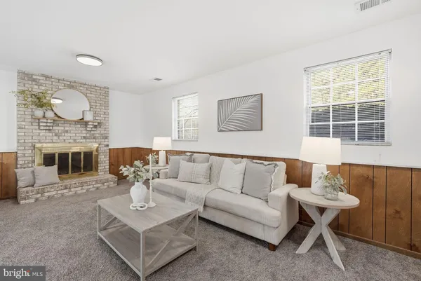 a living room with furniture a fireplace and a table