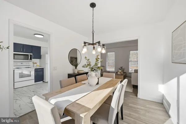 a dining room with furniture a chandelier and wooden floor