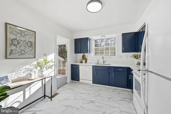 a kitchen with stainless steel appliances kitchen island granite countertop a refrigerator and a sink