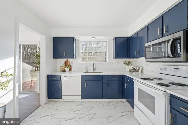 a kitchen with stainless steel appliances granite countertop a stove sink and cabinets