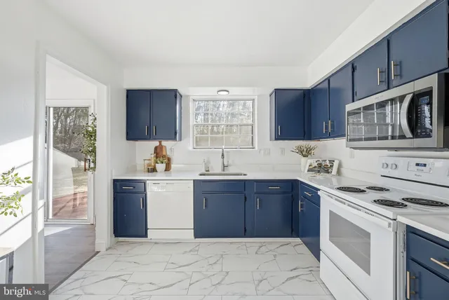 a kitchen with stainless steel appliances granite countertop a stove sink and cabinets