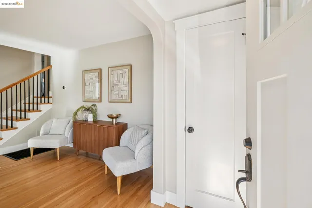a living room with stainless steel appliances furniture a fireplace and a kitchen view