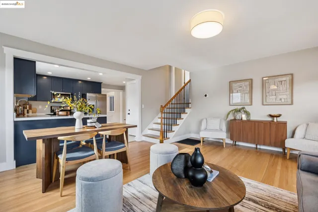 a kitchen with a refrigerator a stove a sink a dining table and chairs