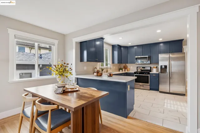 a kitchen with granite countertop a sink a counter top space stainless steel appliances and cabinets