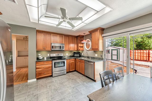 a kitchen with stainless steel appliances granite countertop a stove refrigerator and cabinets
