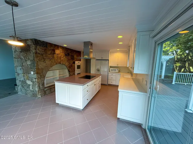 a view of a dinning table and chairs on deck with wooden floor and fence
