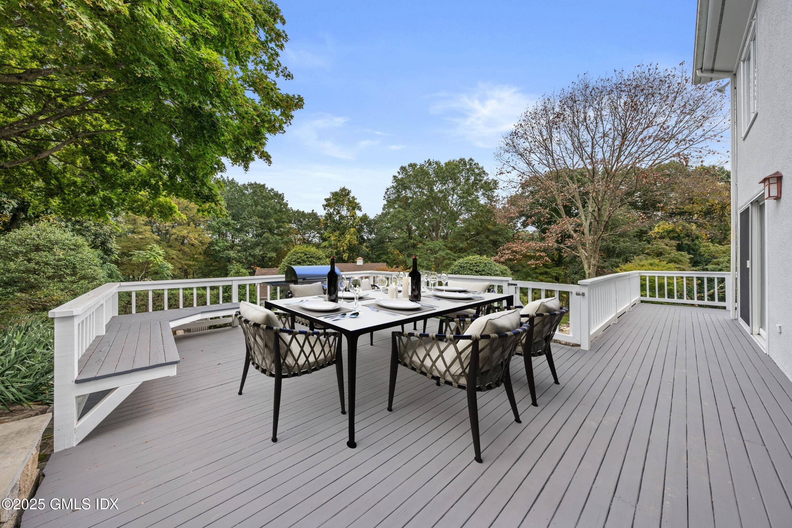 21 Harkim Road Greenwich, CT 06831 - Photo 18 of 40 a view of a dinning table and chairs on deck with wooden floor and fence