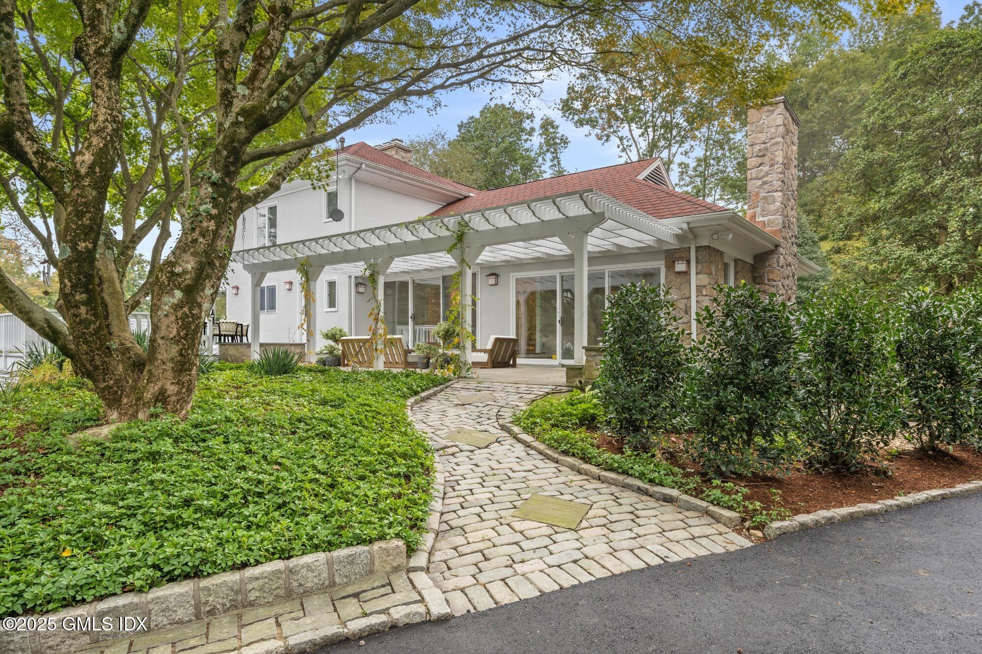 21 Harkim Road Greenwich, CT 06831 - Photo 22 of 40 a front view of a house with a yard and potted plants