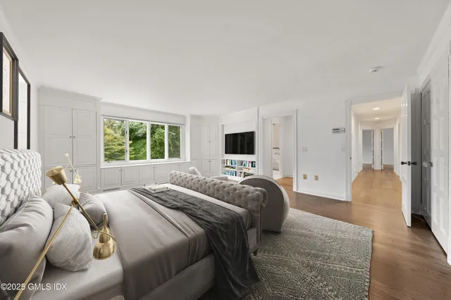 a view of a hallway with wooden floor and windows