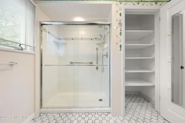 an empty room with wooden floor a fireplace and windows