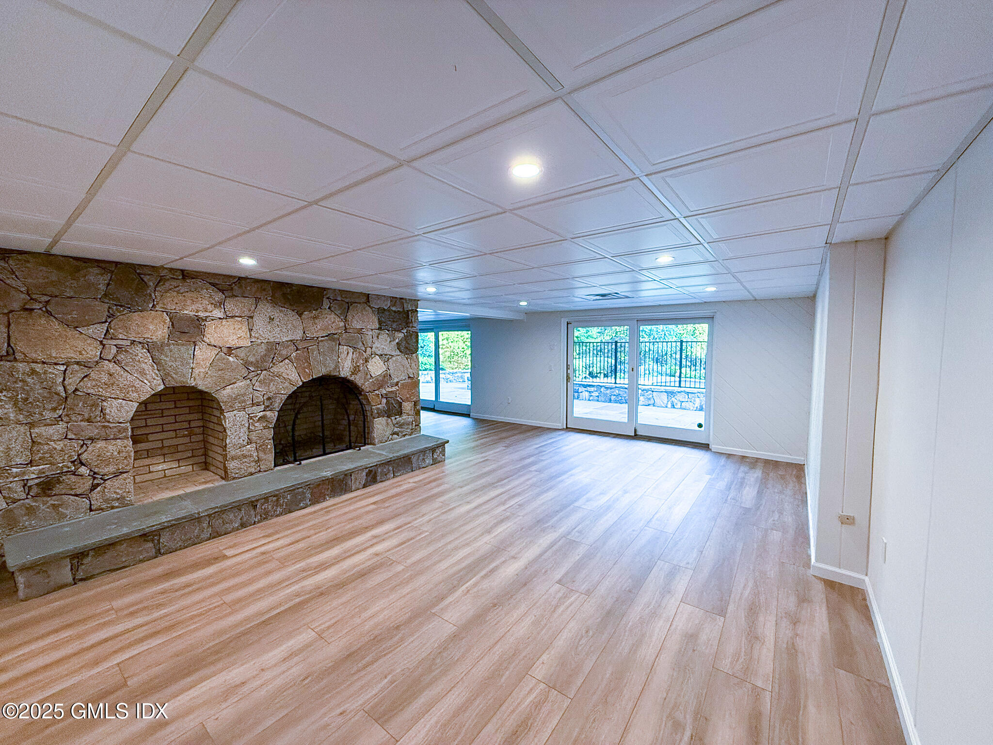 21 Harkim Road Greenwich, CT 06831 - Photo 36 of 40 an empty room with wooden floor a fireplace and windows