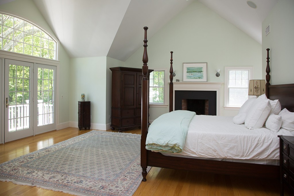 73 Smith Street Wellesley, MA 02482 - Photo 8 of 9 a bedroom with a large bed and a fireplace