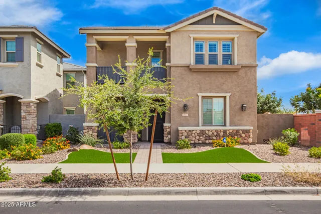 a front view of a house with a yard and potted plants
