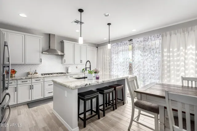 a kitchen with kitchen island granite countertop a sink stainless steel appliances and cabinets