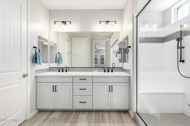 a spacious bathroom with a double vanity sink mirror and shower