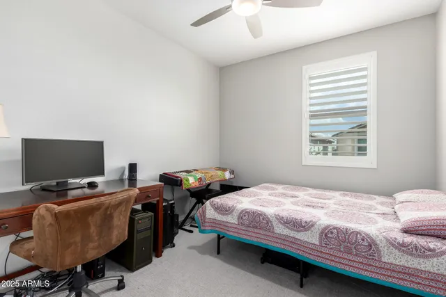 a bedroom with a bed a chair and potted plant