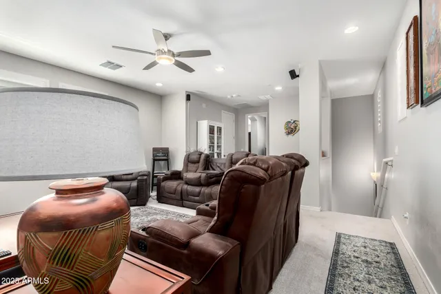 a living room with furniture and a ceiling fan