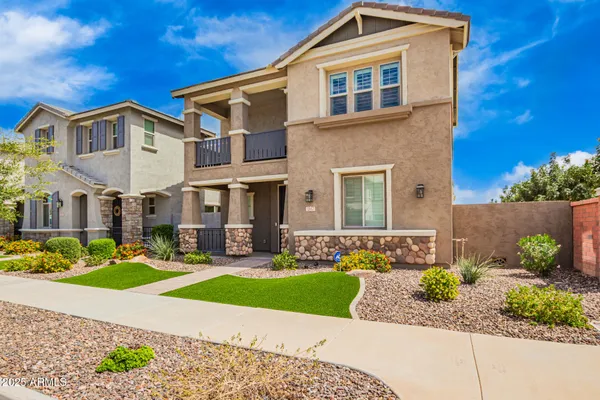 a front view of a house with a yard and potted plants