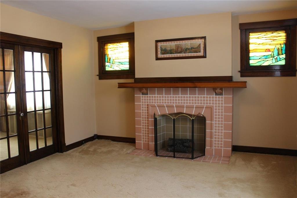 207 Richbarn Road Pittsburgh, PA 15212 - Photo 2 of 12 The fireplace flanked by stained glass windows invites you into the 17 x 14 living room to relax.