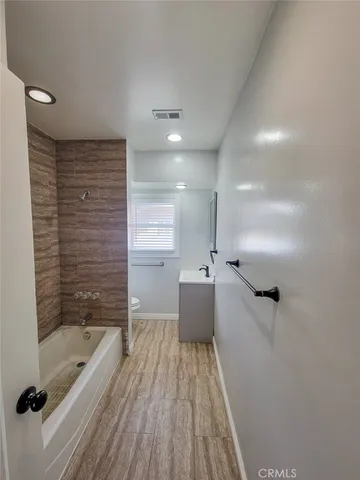 a bathroom with a tub shower vanity and a sink
