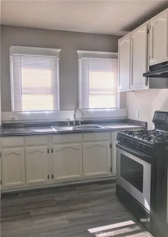 a kitchen with granite countertop cabinets stainless steel appliances and a sink