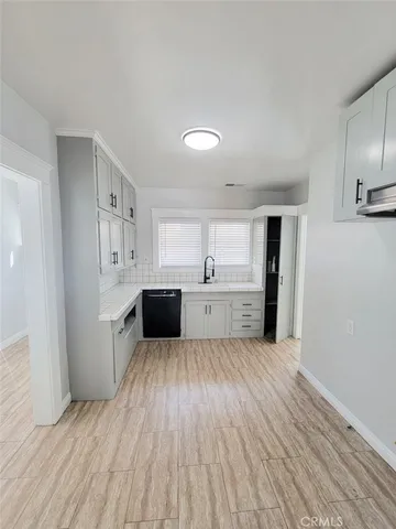 a view of a kitchen with wooden floor and electronic appliances