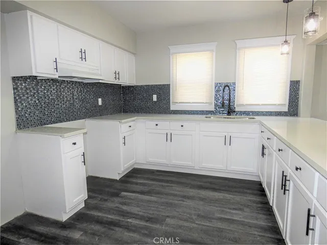 a kitchen with granite countertop white cabinets and sink