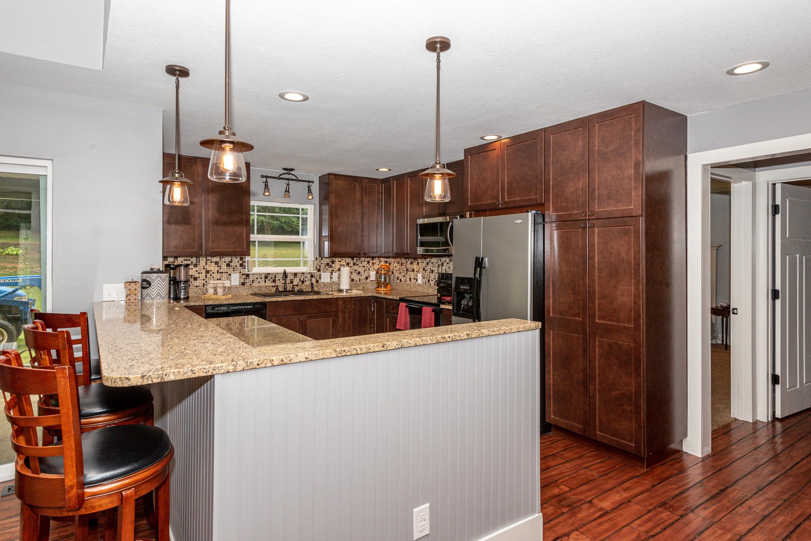 7299 Niles Ferry Road Greenback, TN 37742 - Photo 14 of 38 a kitchen with stainless steel appliances granite countertop a refrigerator a sink dishwasher a stove and a dining table with wooden floor