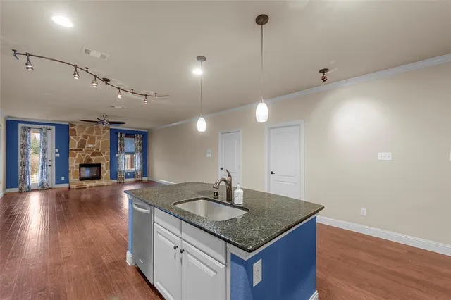 a kitchen with a sink cabinets and wooden floor