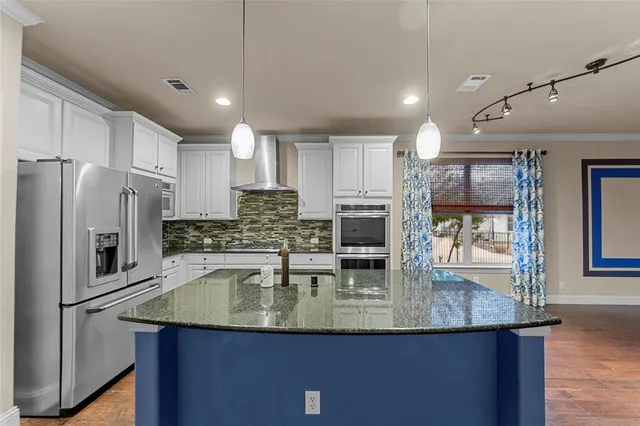 a kitchen with kitchen island a counter top space appliances and cabinets
