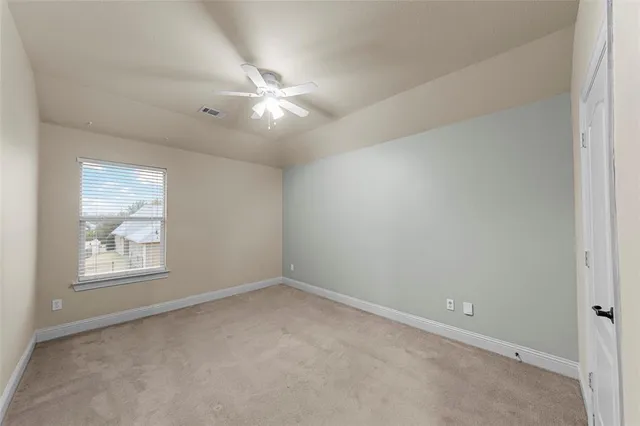 an empty room with windows and fan