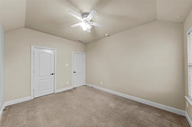 an empty room with a chandelier fan