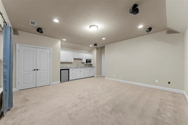 a view of an empty room with a kitchen