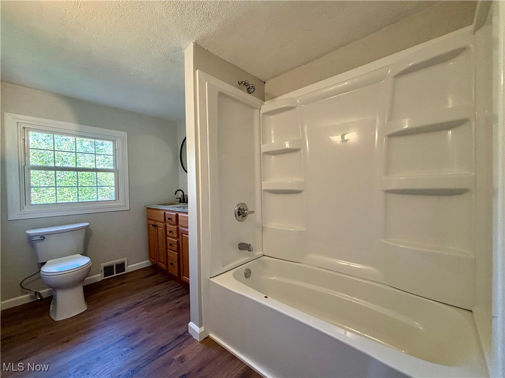 3522 Tent Church Road Colliers, WV 26035 - Photo 9 of 27 Full bath featuring a textured ceiling, shower / washtub combination, dark wood-type flooring, and vanity