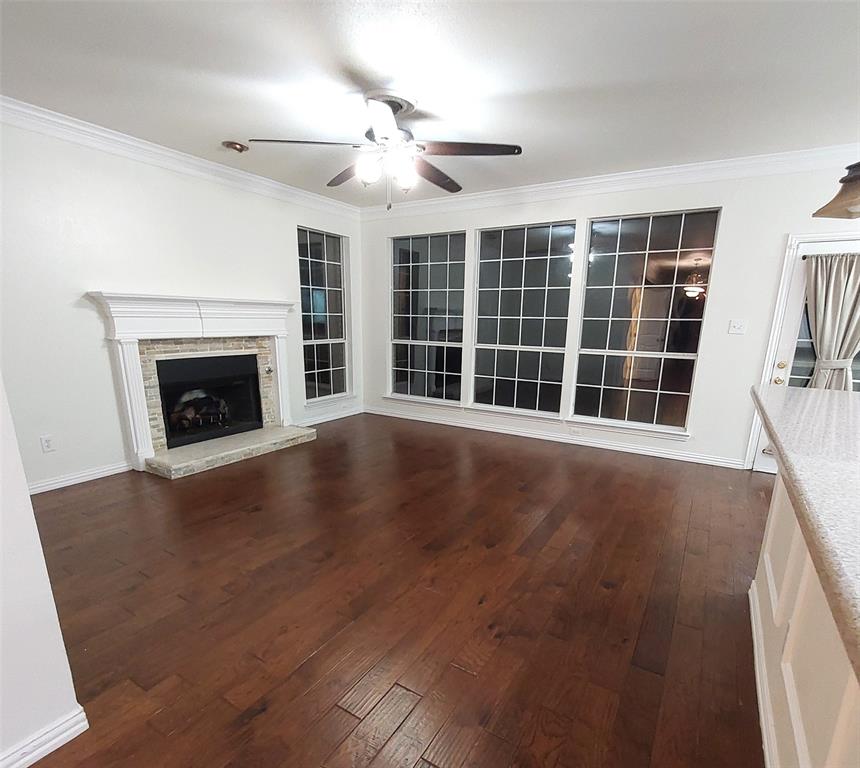 1123 Hampton Drive Allen, TX 75013 - Photo 14 of 33 a view of an empty room with wooden floor fireplace and a window