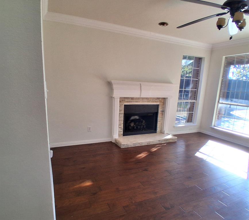 1123 Hampton Drive Allen, TX 75013 - Photo 15 of 33 a view of an empty room with wooden floor fireplace and a window