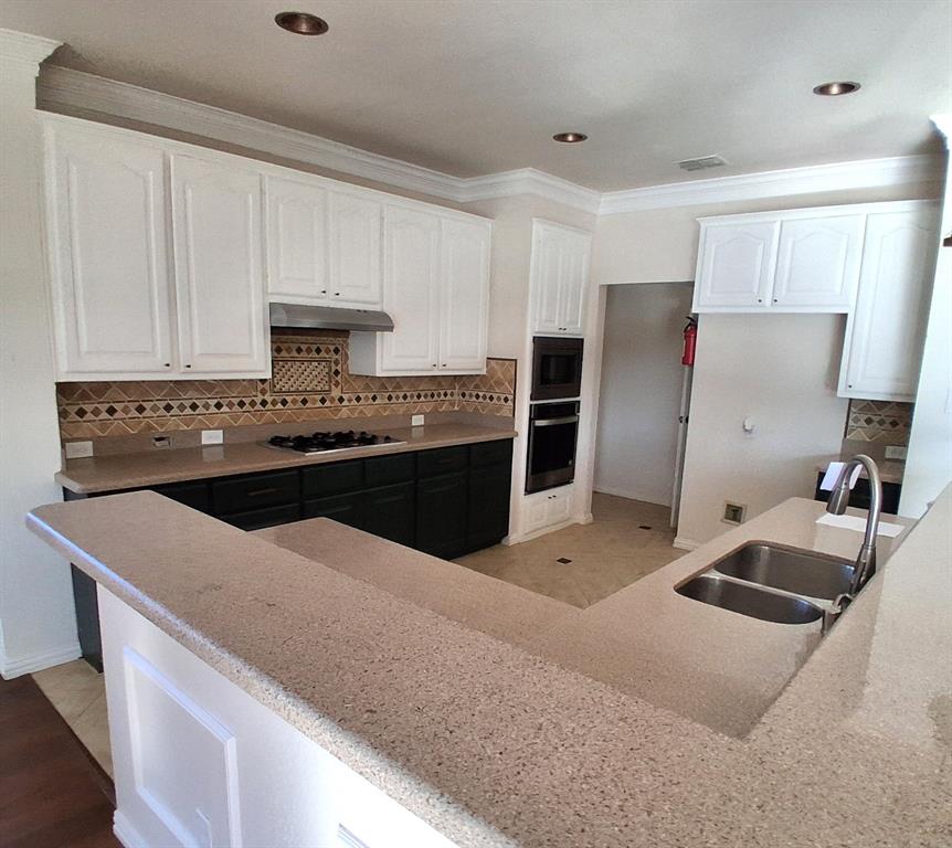1123 Hampton Drive Allen, TX 75013 - Photo 5 of 33 a kitchen with stainless steel appliances a stove a refrigerator a sink a stove with white cabinets