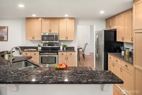 a kitchen with stainless steel appliances granite countertop a sink stove and refrigerator