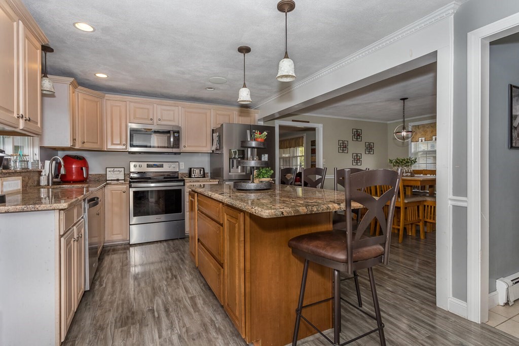 34 Fairview Road Canton, MA 02021 - Photo 7 of 23 a kitchen with kitchen island granite countertop wooden floors and stainless steel appliances