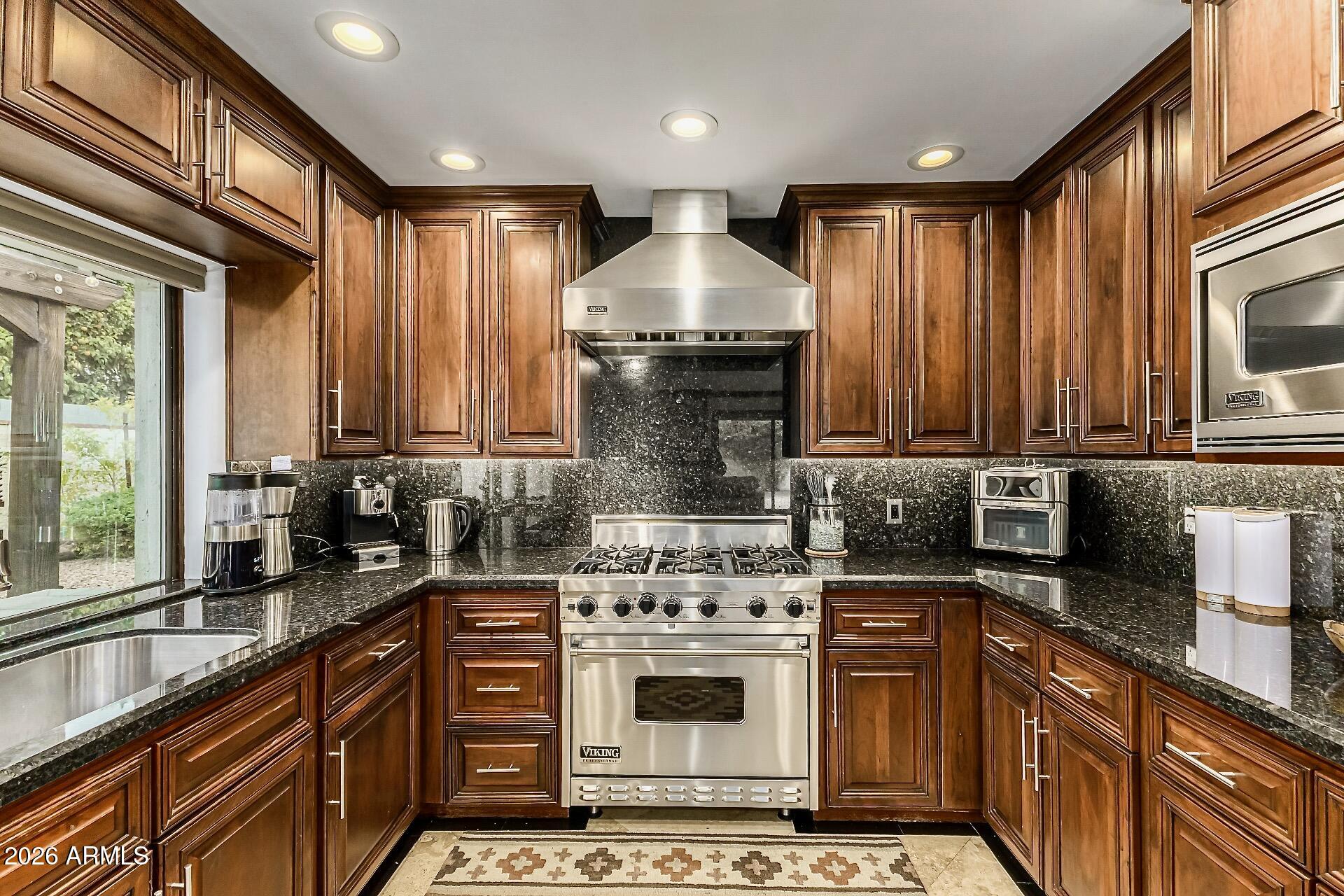 5760 North Scottsdale Road Paradise Valley, AZ 85253 - Photo 3 of 34 a kitchen with stainless steel appliances granite countertop a stove a sink and a microwave