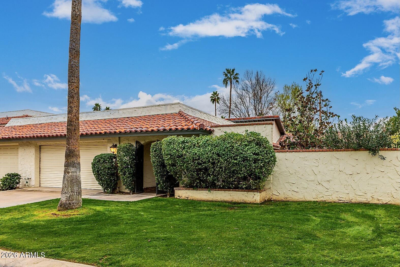 5760 North Scottsdale Road Paradise Valley, AZ 85253 - Photo 33 of 34 a view of a white house with a big yard and potted plants