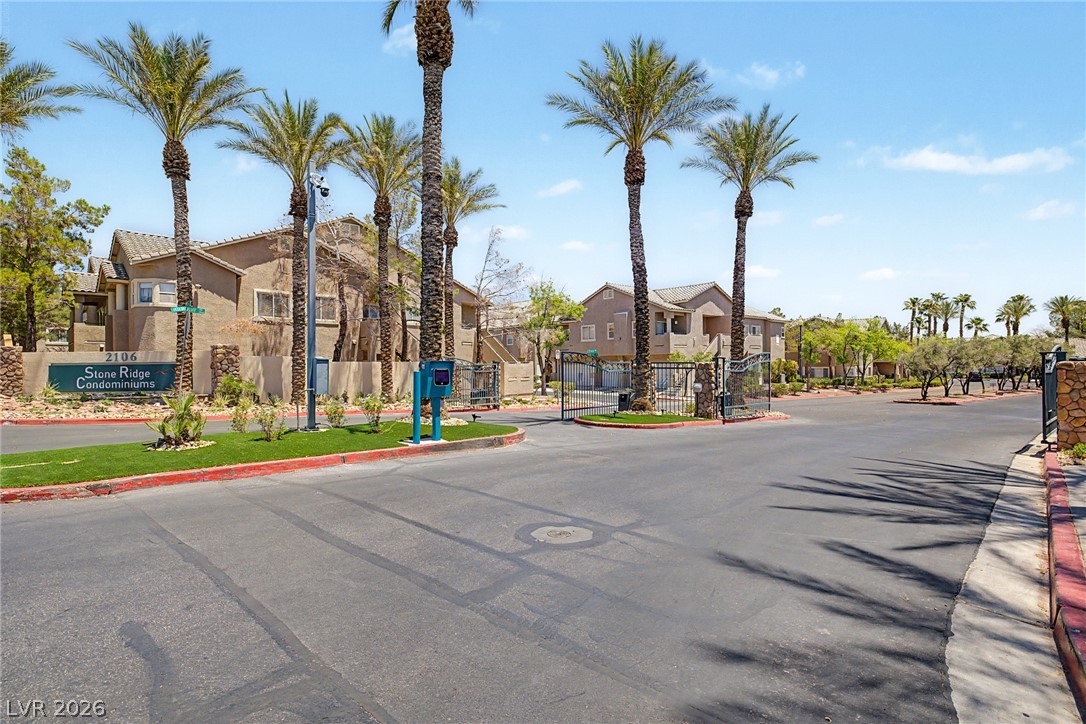 2153 Quarry Ridge Street, Unit 103 Las Vegas, NV 89117 - Photo 32 of 42 Palm-lined entrance to a secure condominium complex, ensuring privacy and ease of access.