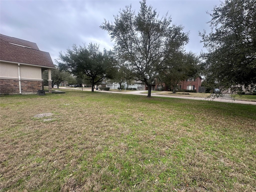 5322 Handbrook Drive Houston, TX 77069 - Photo 7 of 16 a view of a large pool with lawn chairs under an umbrella