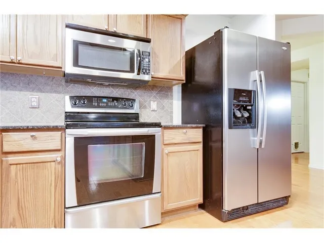 a kitchen with stainless steel appliances granite countertop a stove a sink and a microwave