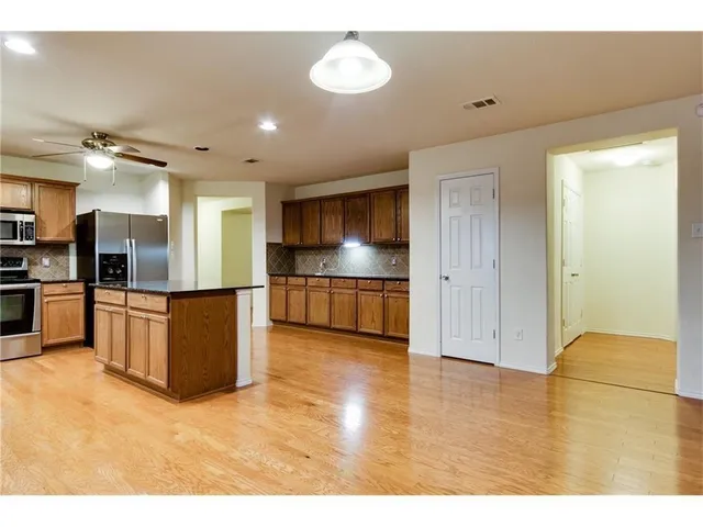a kitchen with stainless steel appliances granite countertop a refrigerator stove and microwave