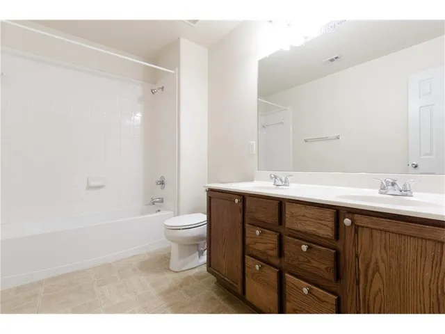 a bathroom with a double vanity sink toilet and shower