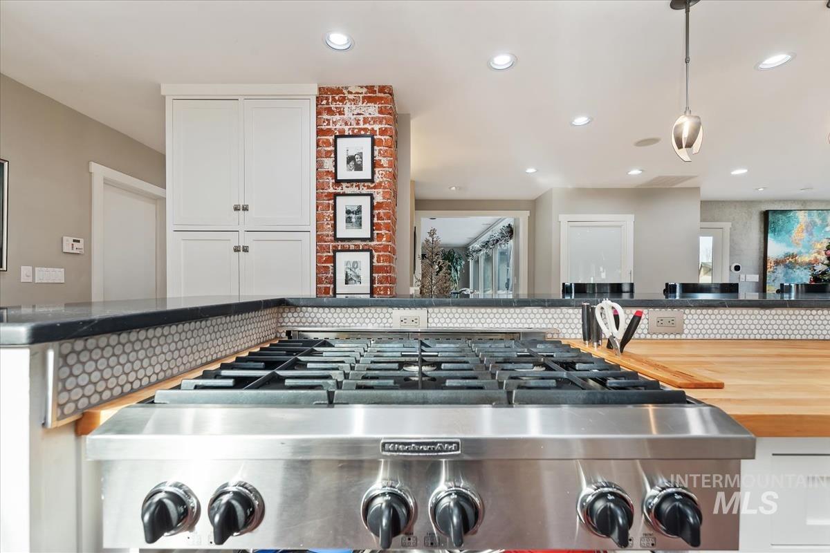 4814 Roberts Road Boise, ID 83705 - Photo 11 of 50 Kitchen view of pendant lighting, white cabinets, butcher block countertops, recessed lighting, and tasteful backsplash