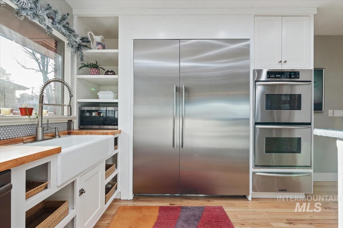4814 Roberts Road Boise, ID 83705 - Photo 12 of 50 Kitchen with white cabinets, appliances with stainless steel finishes, a warming drawer, and open shelves